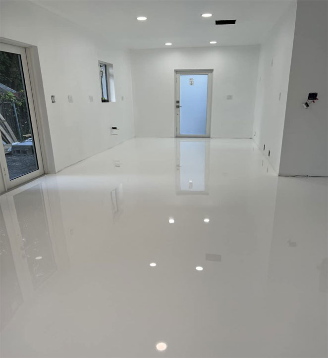 A white wide room with white shiny epoxy floor.