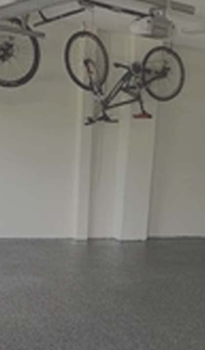 A bicycle hanged upside down in a room with an epoxy flooring.