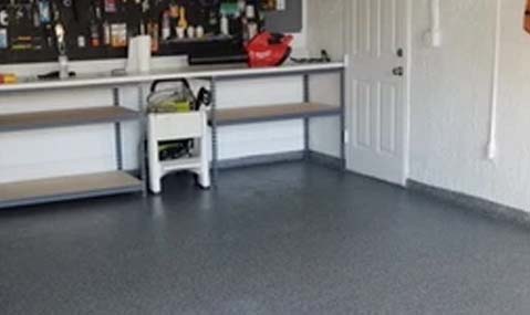 A garage with a floor coated with epoxy flakes.