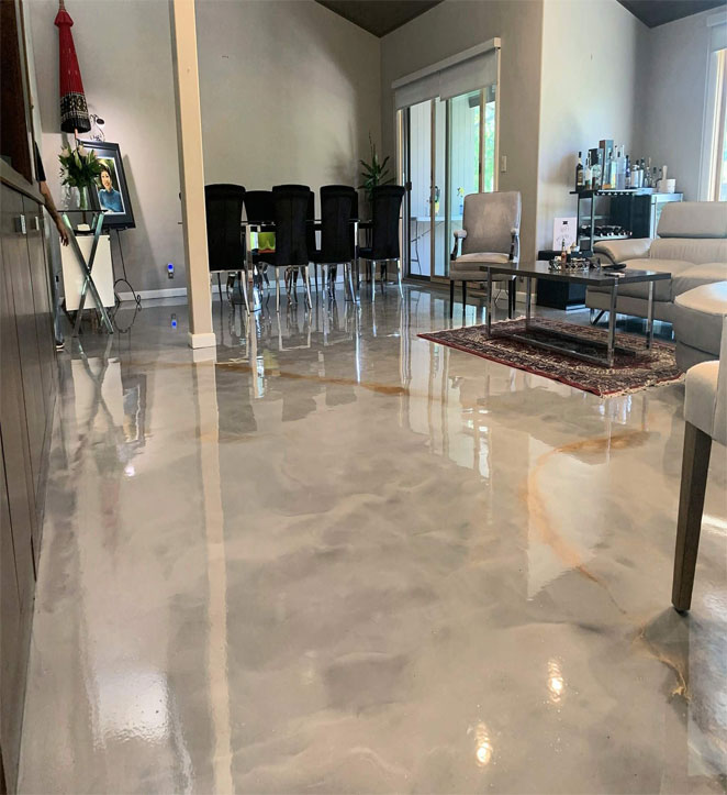 A kitchen with a picture frame, table and chairs, sofa, and a floor coated with epoxy paint.